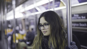 A woman lost in though while riding the subway.
